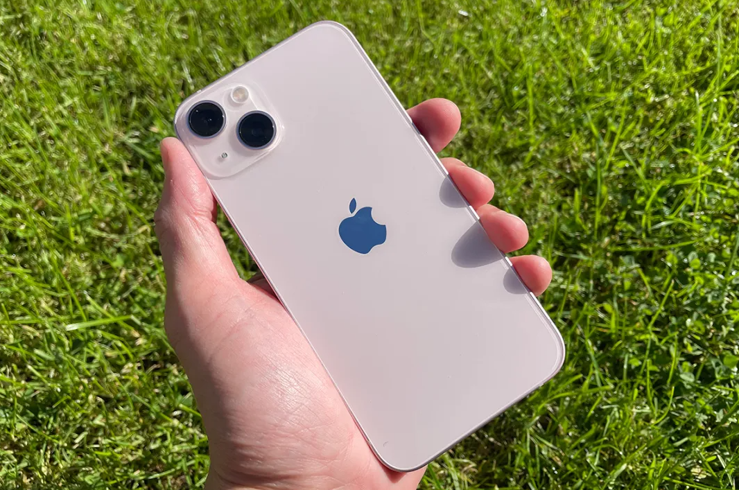 Iphone 13 Storage Guide: What Size Do You Actually Need? Iphone 13 storage, holding iphone 13 outside, grass background