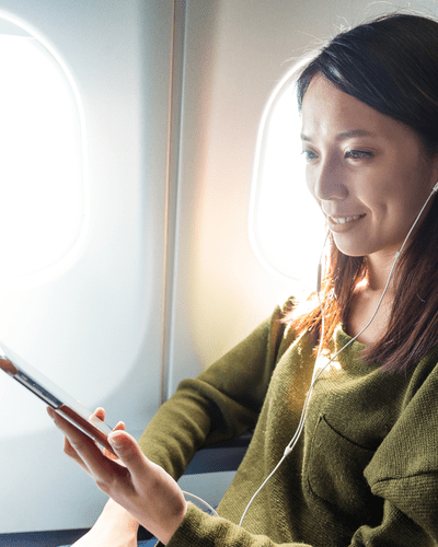 Woman checking refurbished phone on plane